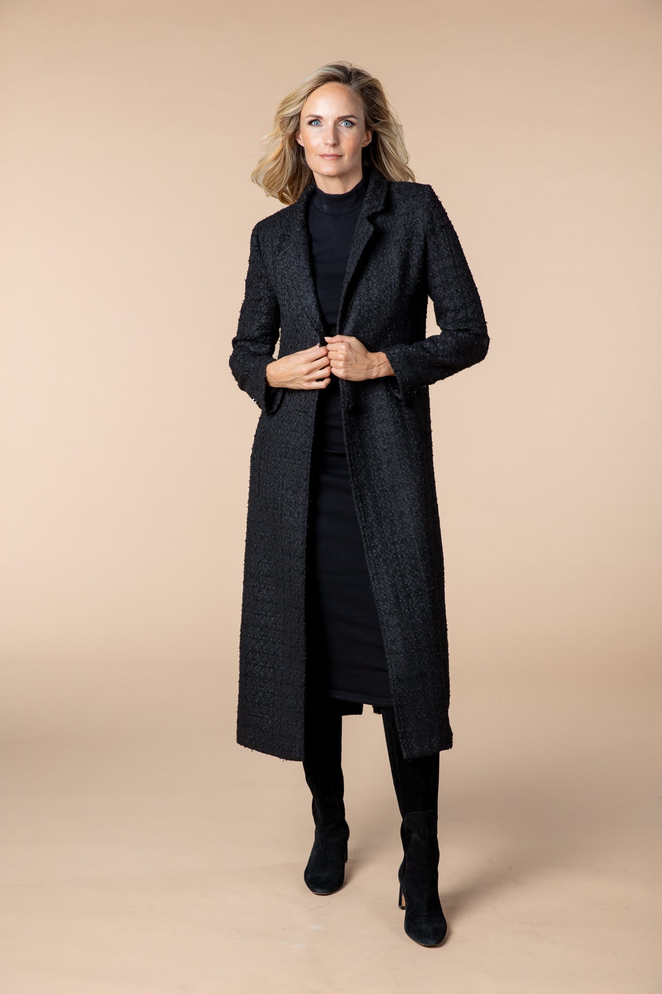 Lang geschnittener schwarzer Mantel für Herbst und Winter mit edlen Knöpfen, praktischem Schlitz hinten und stilvollem Stoff. Ideal für elegante Outfits, ob Hose oder Kleid.