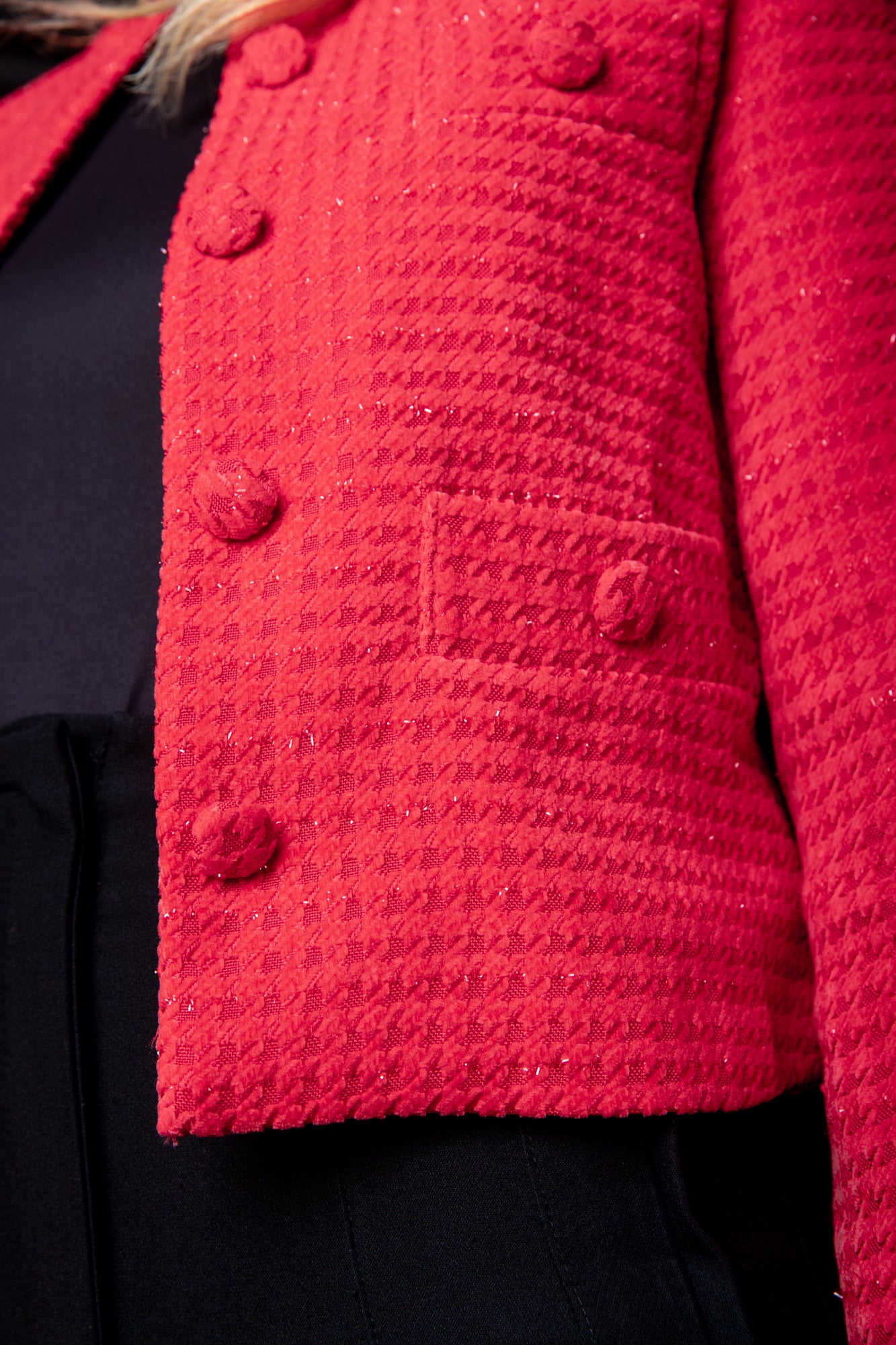 Detailfoto: Moderne rote Jacke im Samt-Look von Tweedheart, mit klassischem Hahnentrittmuster und kurzem Schnitt für einen schicken Auftritt.