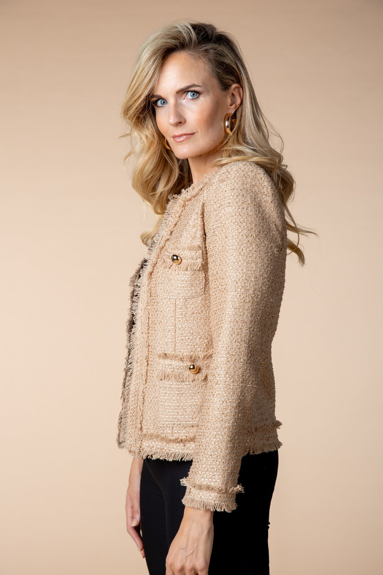 Beige Jacke "Honey Glow" mit goldschimmernden Details und ausgefransten Enden. Ideal für elegante Alltagslooks oder besondere Anlässe, mit einem abgesteppten Rücken und vier aufgesetzten Taschen.