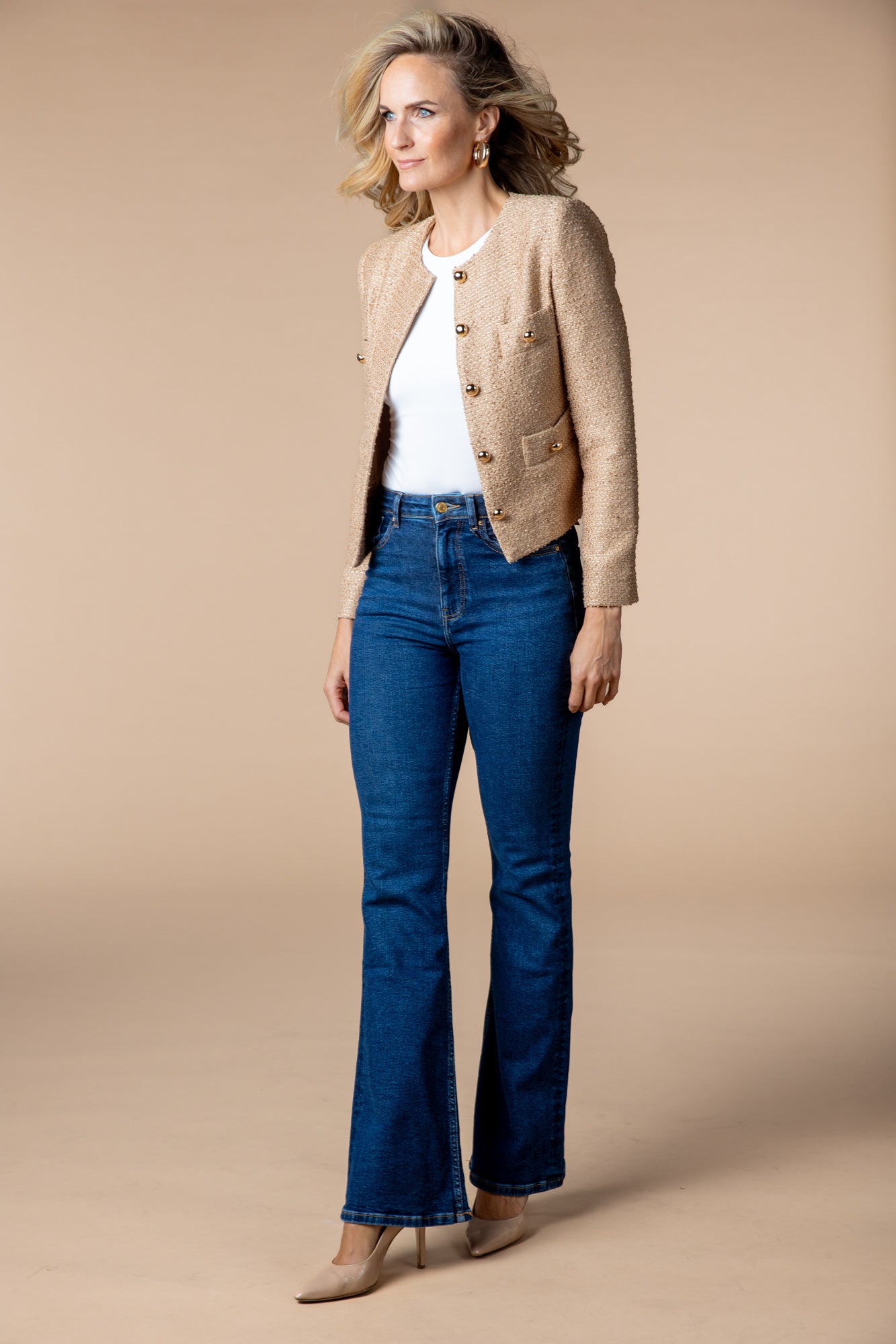 Beige Jacke Honey Bee mit goldenen Knöpfen, kombiniert mit einer klassischen Jeans für einen eleganten und gleichzeitig lässigen Alltagslook. Ideal für einen frischen, modernen Style.